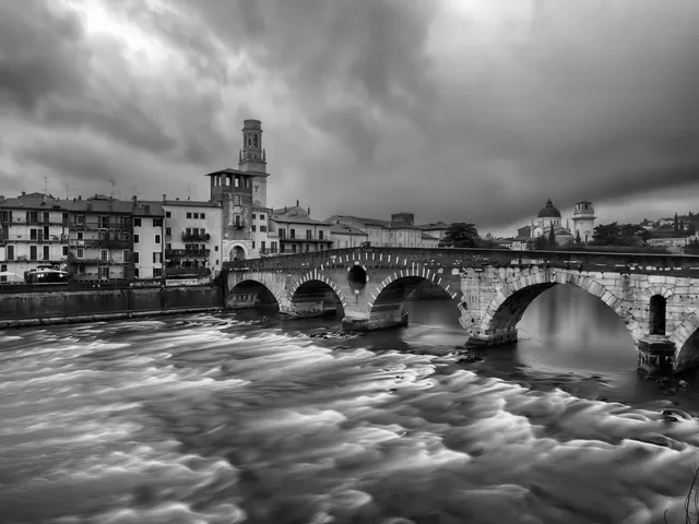 Ponte Pietra sull'Adige in bianco e nero, sotto un cielo di tempesta
