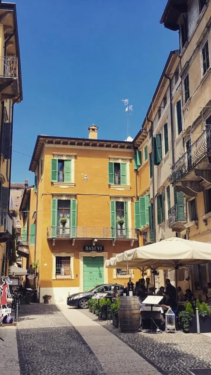 La corte di San Giovanni in Foro con i tavoli della Piazzetta sotto gli ombrelloni – Verona